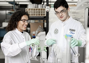 People Advancing Science. Pace scientists smiling at camera, working in Pace laboratory.