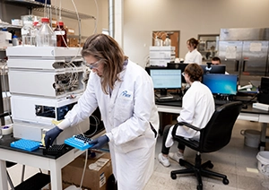 People Advancing Science. Pace scientists smiling at camera, working in Pace laboratory.